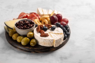 İspanyol jamonlu Charcuterie tahtası, biberli domuz sosisi, fuet, peynir ve brie ile fotokopi alanı olan gri beton arka planda