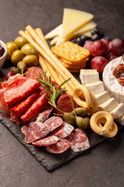 İspanyol jamonlu Charcuterie tahtası, biberli domuz sosisi, fuet, peynirli ve dutlu koyu arkaplan
