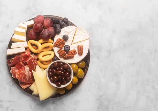 Charcuterie board with spanish jamon, pork sausage with pepper, fuet, cheese and berries