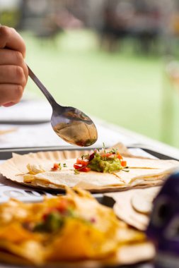 Meksika sokak fast food 'u, taco, fajita ve nachos. Şef kamyonda yemek hazırlıyor ve quesadilla üzerine salsa sosu ekliyor. Seçici odak