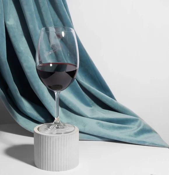 Weinglas Auf Einem Betonpodest Vor Weißem Hintergrund Mit Vorhang Auf — Stockfoto