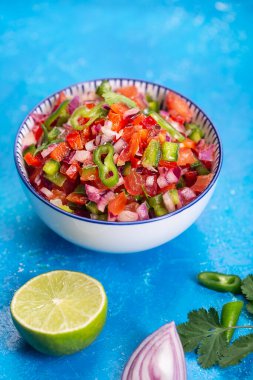 Taze ev yapımı salsa pico de gallo, Meksika mutfağı, mavi arka plan.