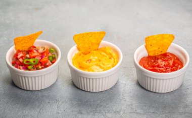 Üç Meksika salsası, pico de gallo, peynir ve baharatlı domates sosu.