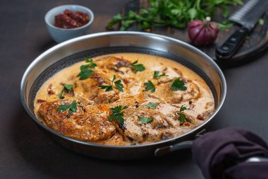 Kremalı soslu kajun tavuğu. Tavada hazırlanmış, koyu arkaplanda.