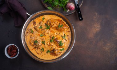 Kremalı soslu kajun tavuğu. Tavada hazırlanmış. Fotokopi alanı olan koyu arkaplan.