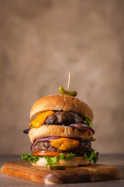 Ev yapımı burger, iki pirzola ve erimiş peynirli soğan ve pastırma.