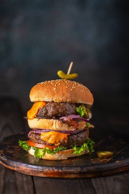 Ev yapımı burger, iki pirzola ve erimiş peynirli soğan ve pastırma.