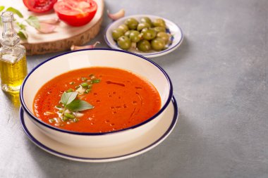 Arka planda geleneksel İspanyol gazpacho tabağı var.