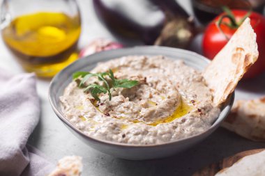 Levantine mutfağı baba ganoush aperatifi. Arkaplanda zeytin yağıyla doldurulmuş pita ekmeği var.