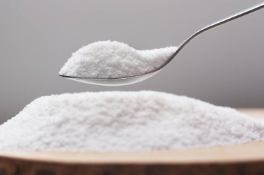 Put natural sweetener stevia from a pile into a spoon clipart
