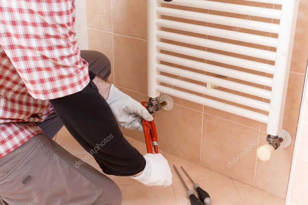Plumber performs a repair of a radiator