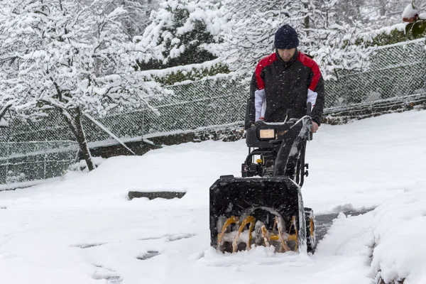 Mann beseitigt Schnee mit Schneefräse — Stockfoto