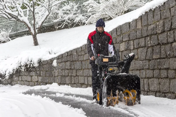 Hombre quitando nieve con un soplador de nieve — Foto de Stock