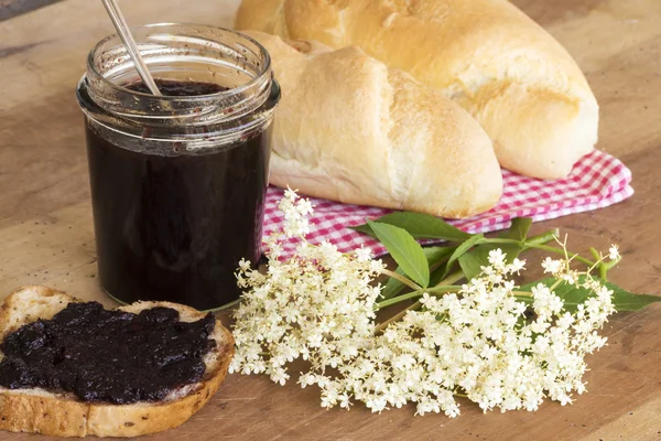 ekmek ve çiçekli dal üzerinde mürver marmelat yaymak