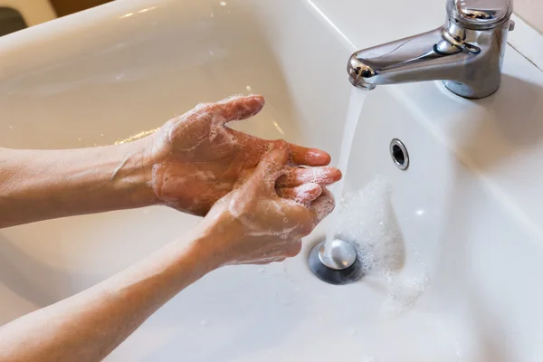 Frau wäscht Hände mit Seife in der Spüle — Stockfoto