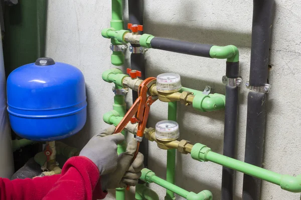 Rörmokare på jobbet som installerar en vattenmätare — Stockfoto