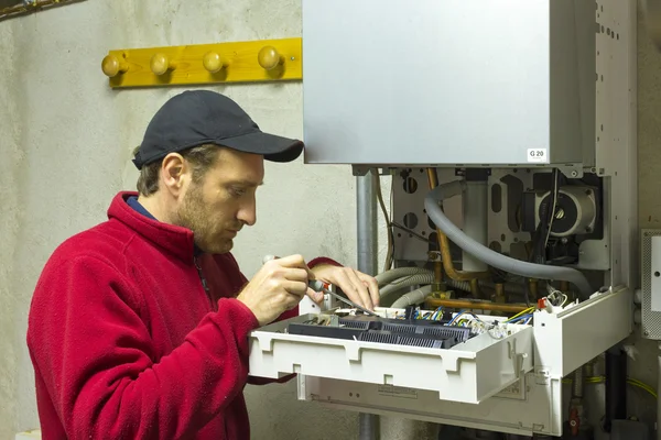 Hydraulik naprawiający kocioł kondensacyjny — Zdjęcie stockowe