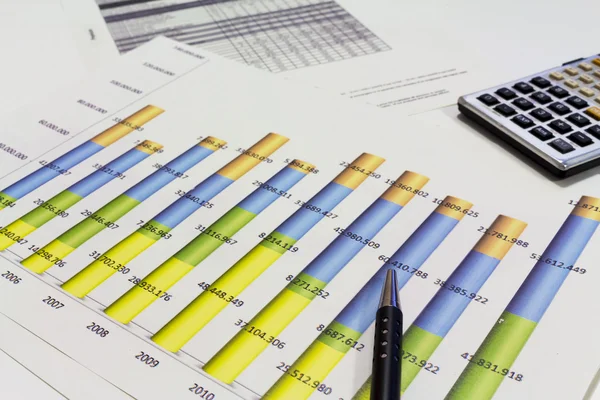 An office desk with charts and histograms graphical documents — Stock Photo, Image