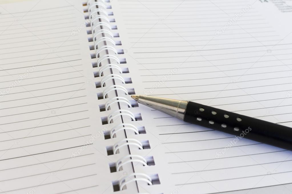 close-up of pen and diary calendar on an office desk