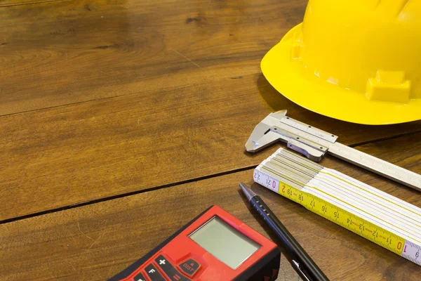 Safety helmet and tools to architect on wooden background — Stock Photo, Image