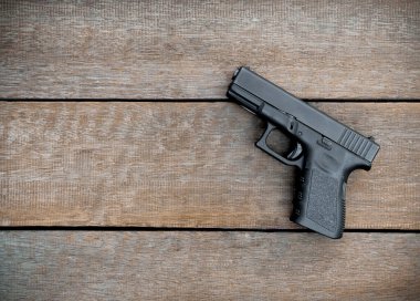 Siyah çelik polimer yarı otomatik 9mm tabanca, ahşap zemin üzerinde, Boşluğu Kopyala