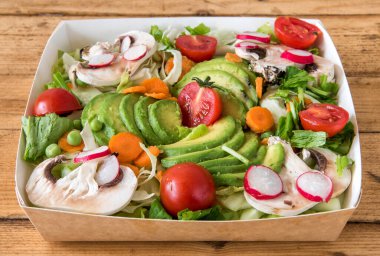 avokadolu salata, kiraz domatesleri, mantarlar, havuçlar, bezelyeler, turplar, geri dönüşümlü kağıtlarla paketlenmiş paketler.