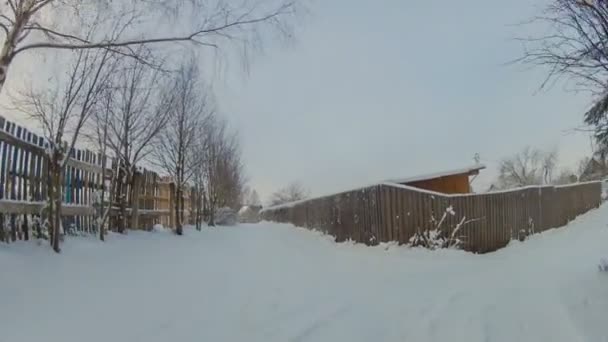 Conducir en camino nevado cerca de una cerca rústica de madera — Vídeos de Stock