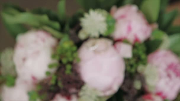 Anneaux de mariage allongés sur un bouquet de pivoines — Video