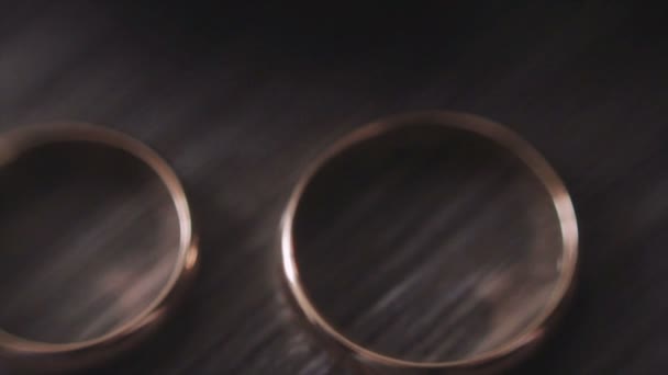 Dos anillos de boda de oro en la mesa — Vídeo de stock