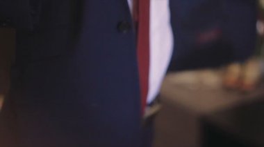 Omzunun üzerinden bir ceket giyen damat