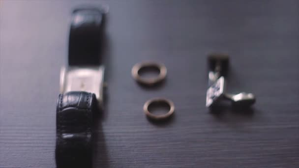 Relógios de pulso, anéis e dois pregos na mesa — Vídeo de Stock