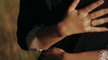 Gelin ile damat kollarını. Tatil gün batımında iki aşık