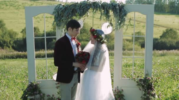 Sposa e sposo tenendo le mani vicino ad arco di nozze — Video Stock