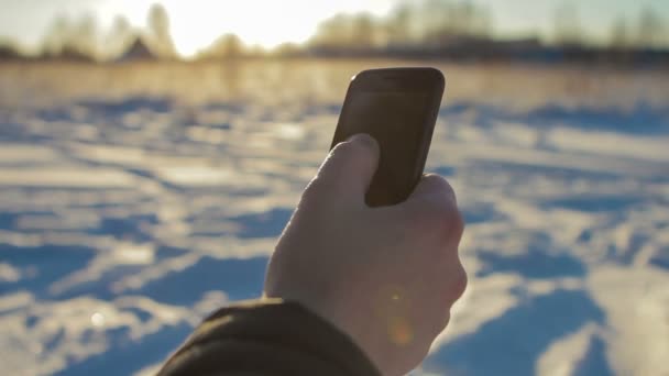 La mano del hombre usando el teléfono inteligente en el primer plano de invierno — Vídeos de Stock