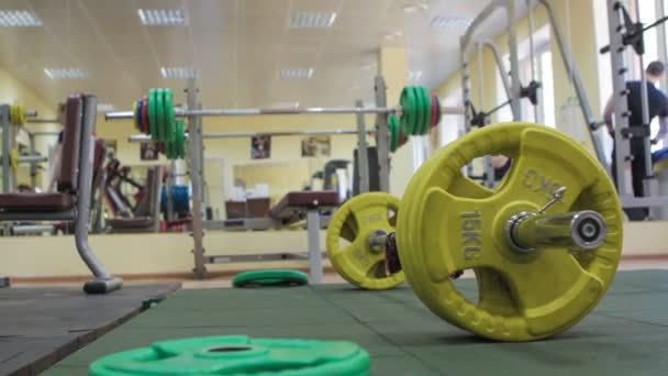 Closeup barbell, the green barbell plates are on the floor — Stock Video