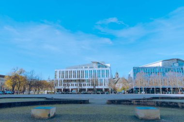 Modern DomQuartier inşaat kompleksi Magdeburg, Domplatz 'da arka planda barok St. Sebastian Kilisesi ile parlak mavi sonbahar gökyüzünün altında.