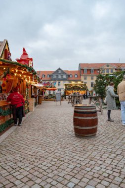 Wolfenbuettel 'deki Noel pazarındaki aydınlanmış tezgahların ziyaretçileri, 25 Kasım 2025' te saat 15: 27 'de fotoğraflandı. Ağaçlar ve süsler bir kış ortamı yaratır.