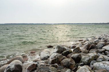 Yumuşak kış ışığı Baltık Denizi boyunca parıldayan bir yansıma yaratır. Önplanda buzla kaplı kayalar, yatay biçimdeki sakin ufuk ile zıtlık oluşturur.
