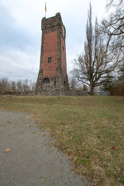 The Bismarck Tower on Flaemingberg near Burg rises above the surrounding landscape. The tower platform features a flag and a fire bowl, a characteristic element of many historic Bismarck monuments.