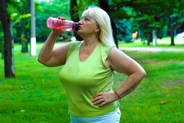 Mujer Rubia Edad Avanzada Bebe Agua Parque Una Anciana Practicar —  Fotos de Stock