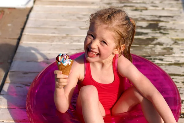 Gelukkig Klein Blond Meisje Zit Een Roze Zwemmen Ring Eet — Stockfoto