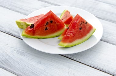 Beyaz bir plaka üzerinde sulu karpuz parçalar