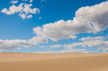 Çöl kumları ve mavi gökyüzü bulutlu