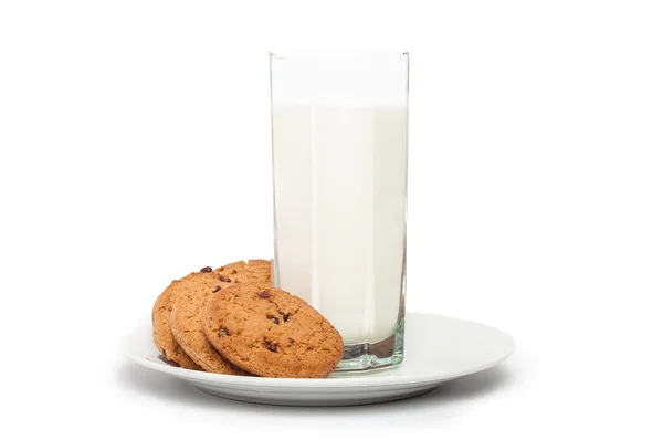 Вівсяне печиво в тарілці та молоці у високій склянці ізольовано на білому ба Стокова Картинка
