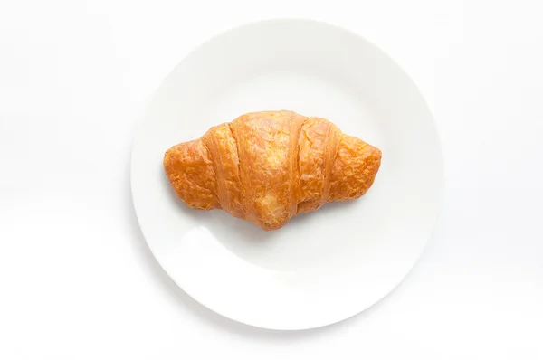 Croissant op witte plaat, bovenaanzicht. Zweet gebakken dessert in dis Stockfoto