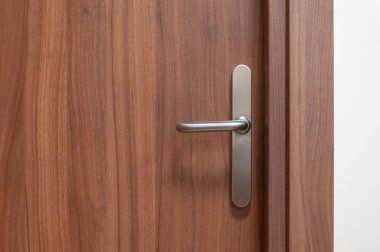 Wooden door with metal knob. Closed entrace to the office. clipart