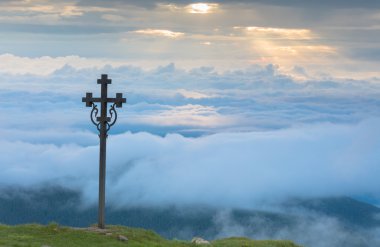 Bulutlar dağlarda bir arka plan üzerinde Hıristiyan çapraz