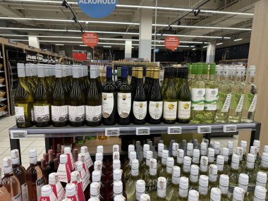 Varşova, Polonya - 24 Eylül 2025: Süpermarket raflarında düzenlenmiş şarap şişeleri, farklı marka ve tipler, davetkar bir alışveriş ortamı yaratıyor
