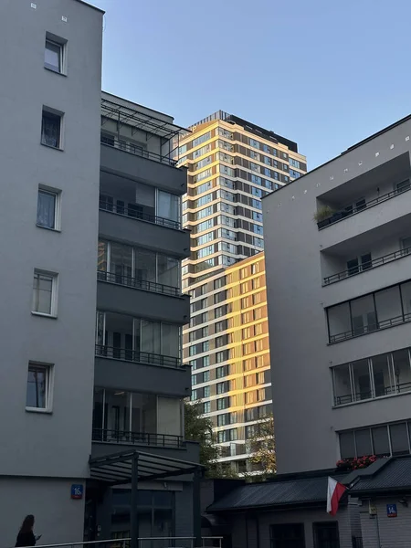 Varşova, Polonya - 24 Eylül 2025: Yüksek binalar güneş ışığında parlıyor, konut binaları arasına yerleşmiş, kentsel mimariyi ve modern yaşamı ön plana çıkarıyor