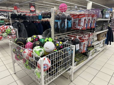 Varşova, Polonya - 28 Ekim 2025: Canlı renklerde çeşitli futbol topları perakende satış mağazası koridorlarında sergilenmekte, spor severler ve müşteriler cezbedilmektedir